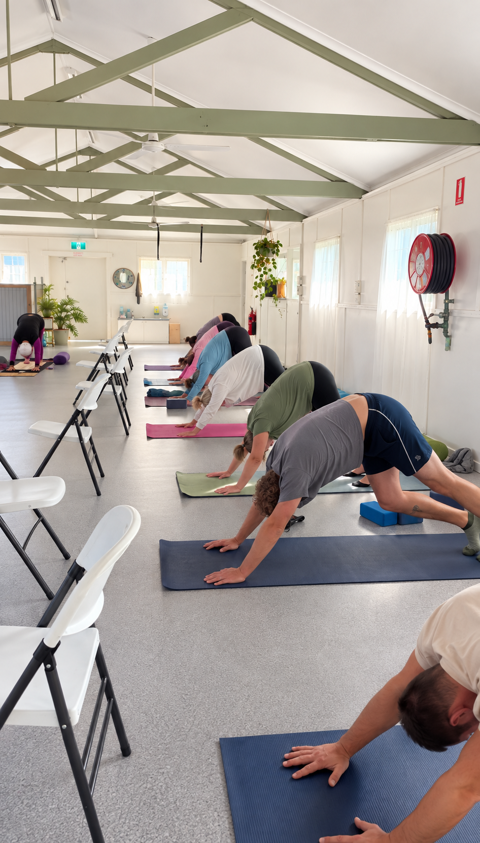 Students moving through a supported yoga flow with chairs and mats