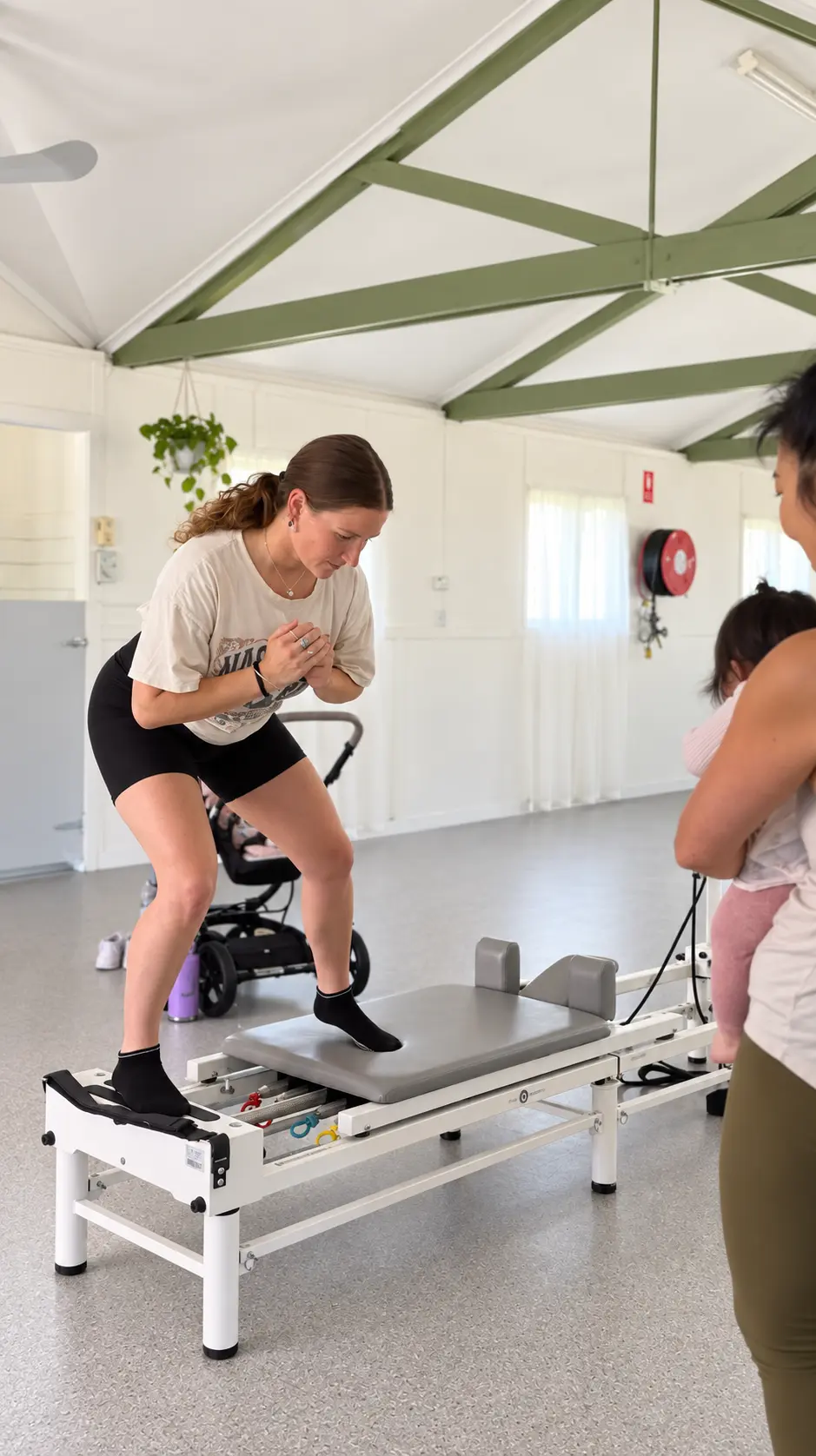 A student practising a standing exercise on the Pilates reformer